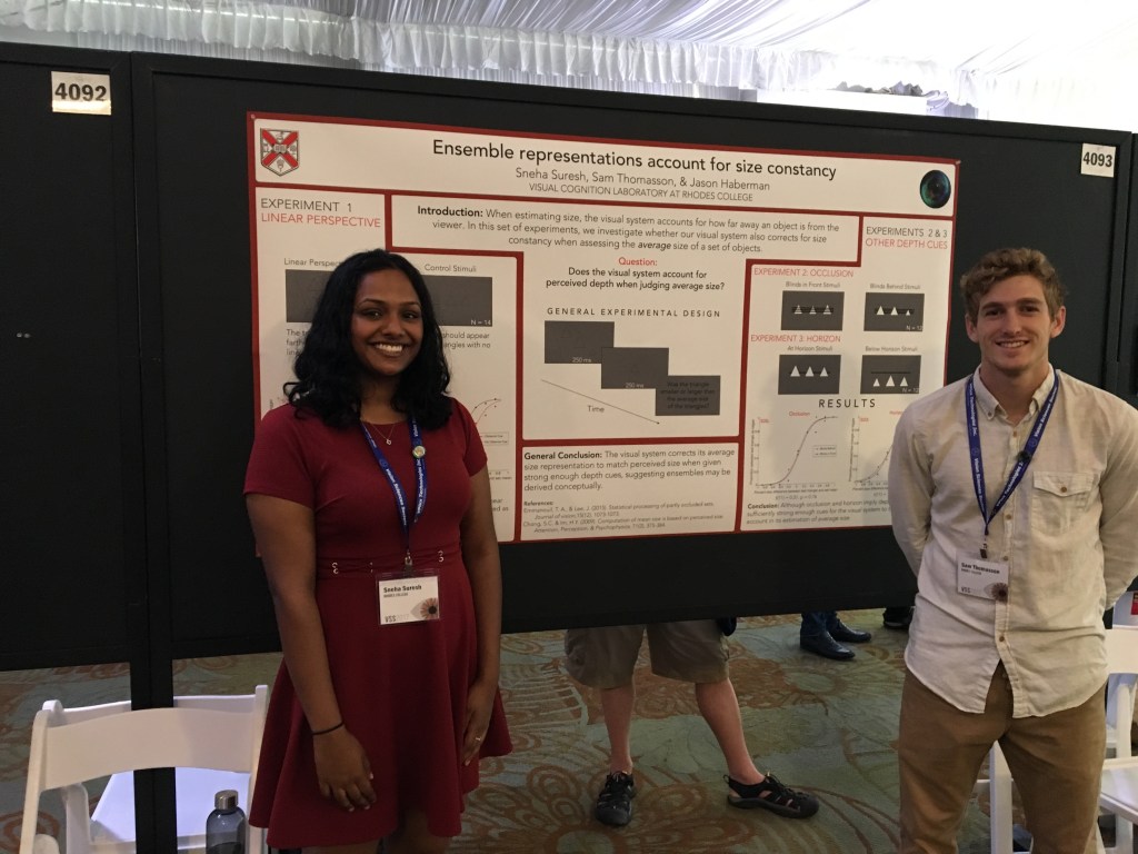 Student researcher beside a VSS poster